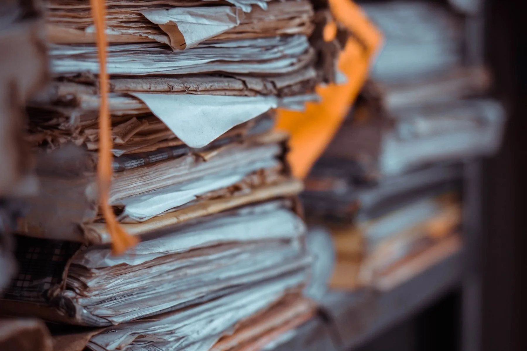Rows of labelled paper case files standing on a records-office shelf