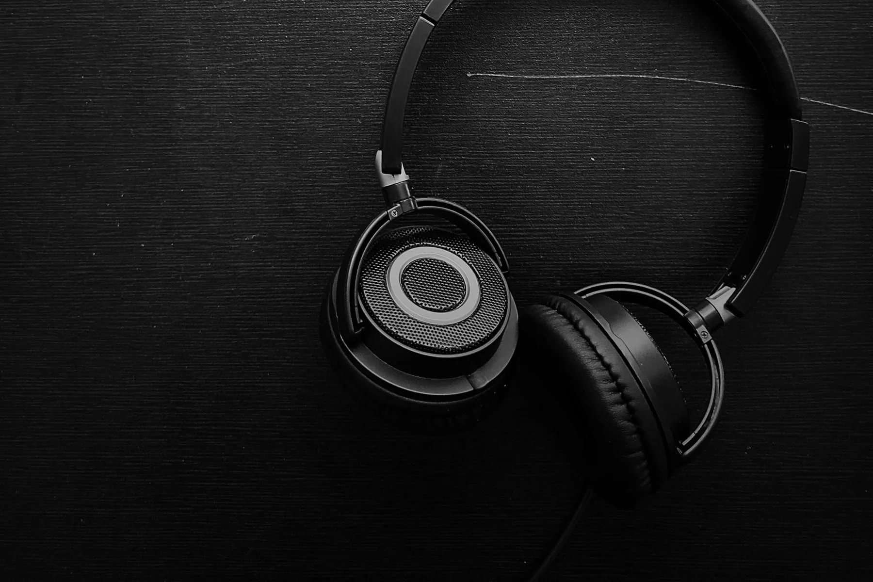 Over-ear headphones laid flat on a black surface