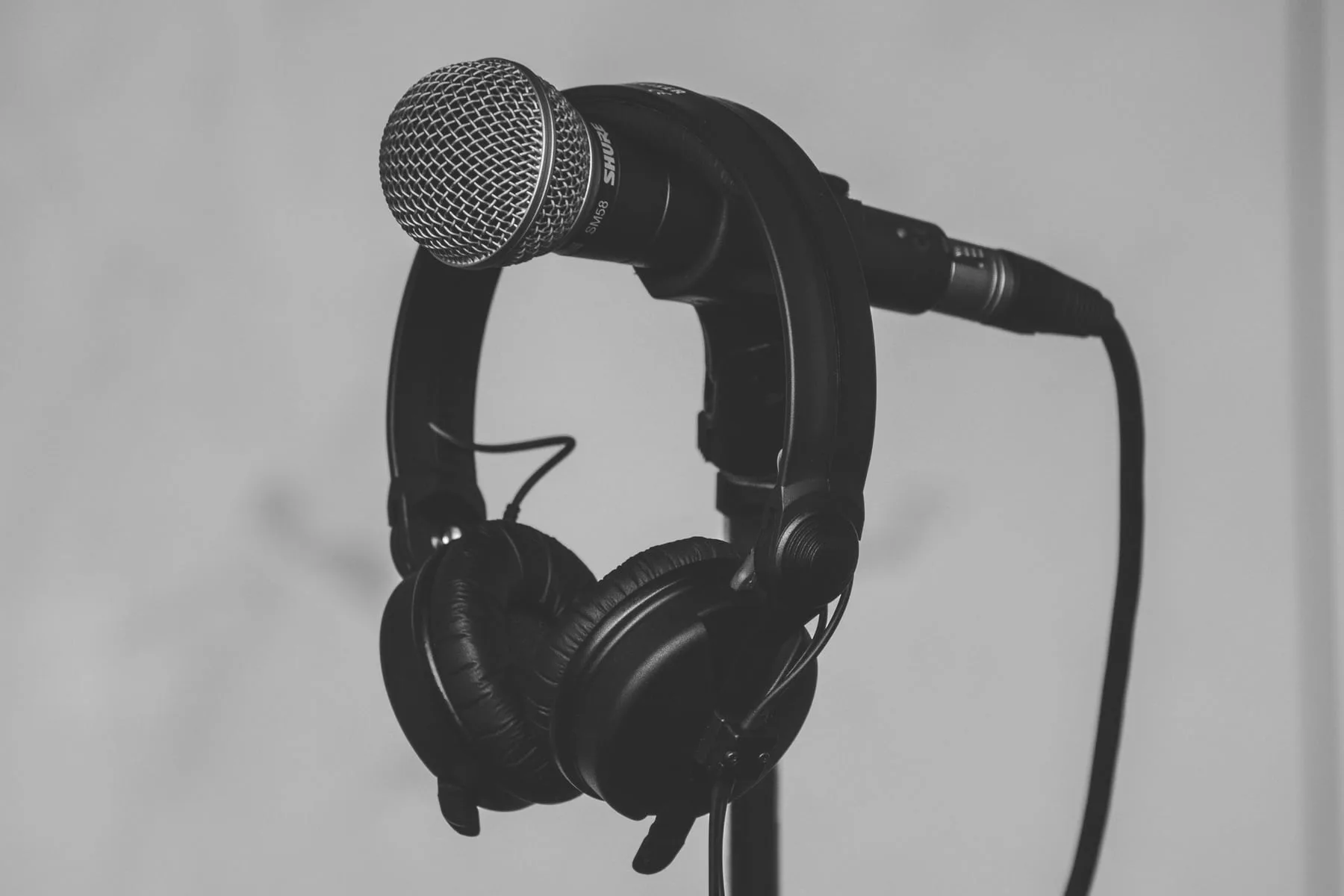 Headphones and a microphone on a stand, photographed in black and white