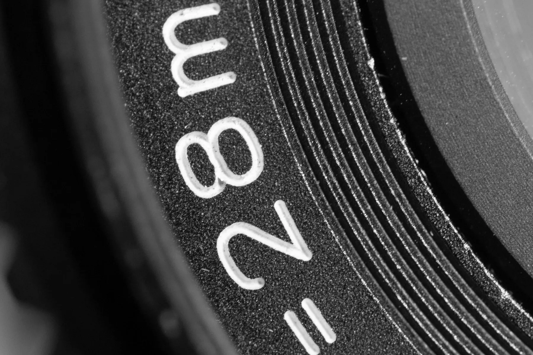 A camera lens barrel close up, with the focal length scale in focus