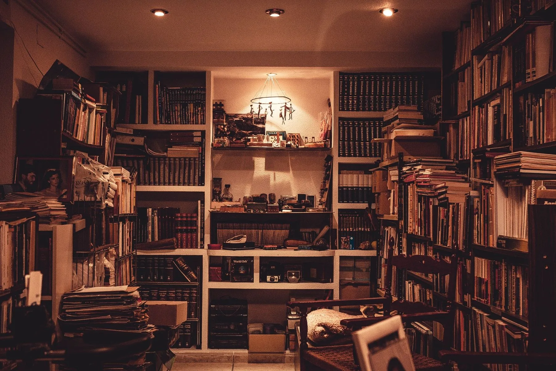 A wood-panelled reading room lined with bookshelves and framed prints