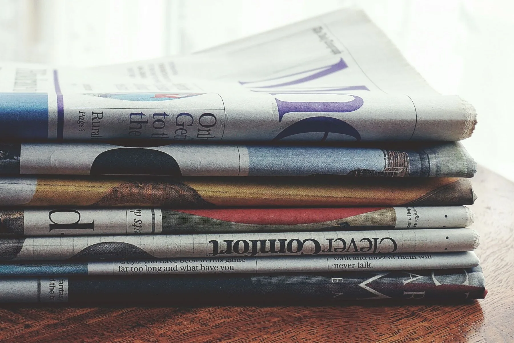 A stack of folded daily newspapers on a table