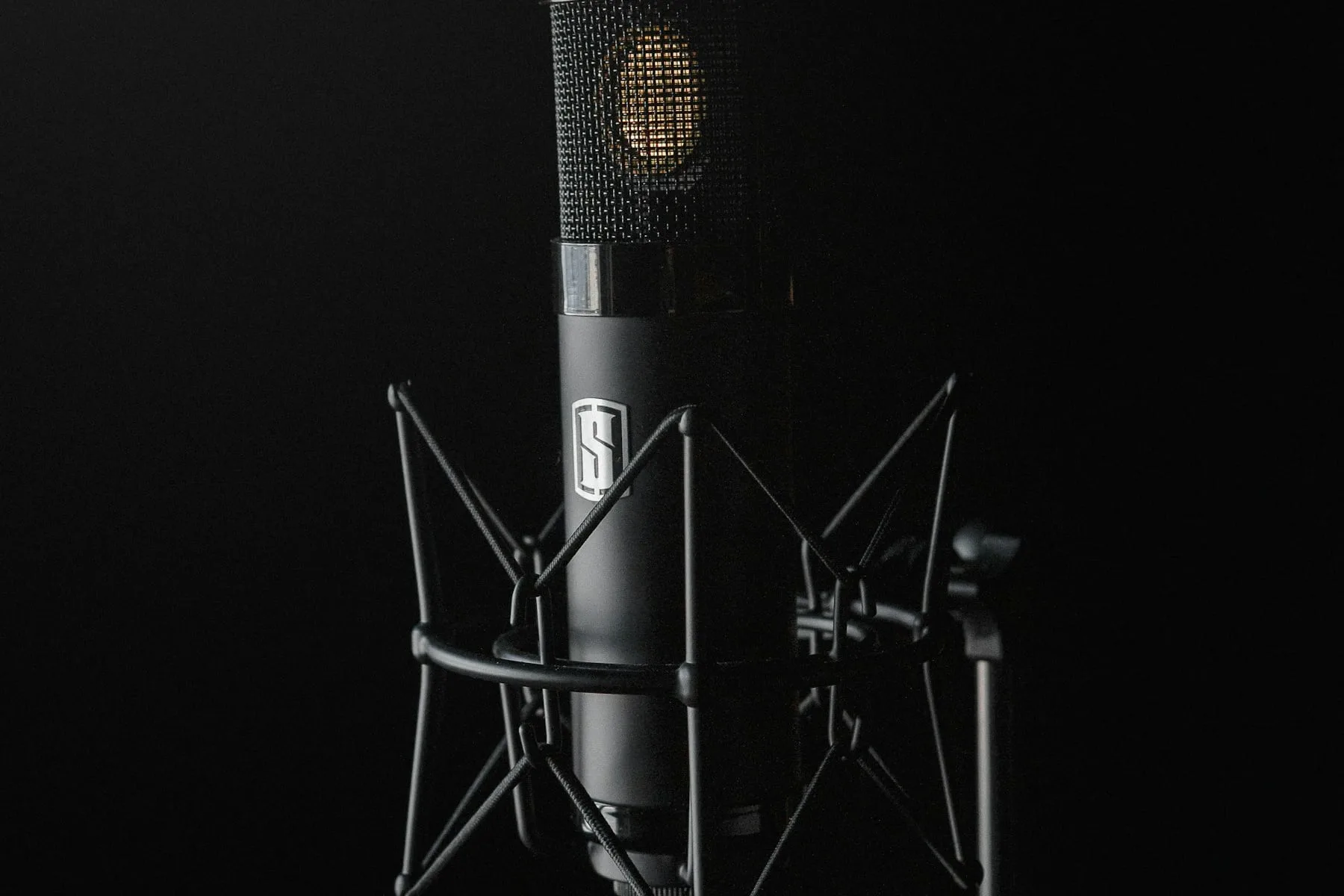 A condenser microphone against a black background